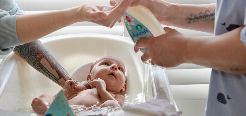Bathing newborn with Johnson's® CottonTouch™ newborn wash & shampoo